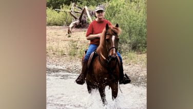 a woman on her horse in a creek